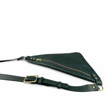Load image into Gallery viewer, A dark green triangular leather crossbody bag with a zippered front pocket and an adjustable strap with solid brass hardware, shown on a plain white background.