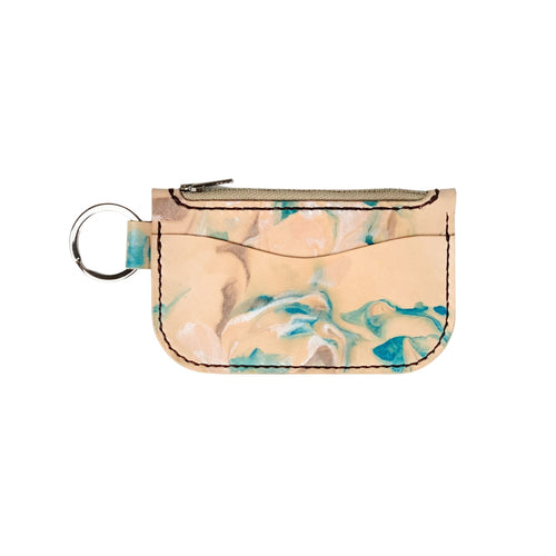 Front view of a leather key chain zipper wallet with one front pocket, one zipper pocket and a shiny nickel key ring attached.  Leather is a light natural color painted with water colors: brown, turquoise and and pearlescent white dyes.  Dark brown thread.