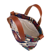 Load image into Gallery viewer, Overhead view of women's southwestern mini tote handbag. Chestnut brown leather handles. Antique brass hardware on sides of purse to attach a strap. Interior magnetic closure. Cream linen interior lining with slip pocket.