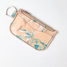 Load image into Gallery viewer, Front angle view of  leather key chain zipper wallet with one front pocket, zipper pocket and a shiny nickel key ring attached. Leather is a light natural color painted with water colors: brown, turquoise and and pearlescent white dyes.  Dark brown thread.
