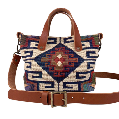 Front view of women's southwestern mini tote handbag. Chestnut brown leather handles with a removable, buckle adjustable strap.  Antique brass hardware.